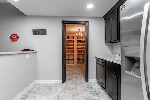 wine cellar with baseboards and a chandelier