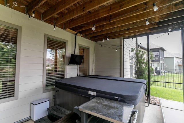 view of patio / terrace with a hot tub and fence