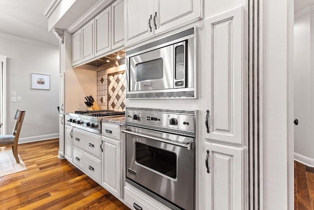 4710 Winding Wood Ct, Columbia, MO 65203 - kitchen with appliances with stainless steel finishes, ornamental molding, backsplash, white cabinetry, and dark wood finished floors
