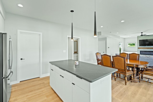 540 Angels Rest Way, Columbia, MO 65203 - kitchen featuring freestanding refrigerator, dark countertops, a ceiling fan, light wood finished floors, and a kitchen island
