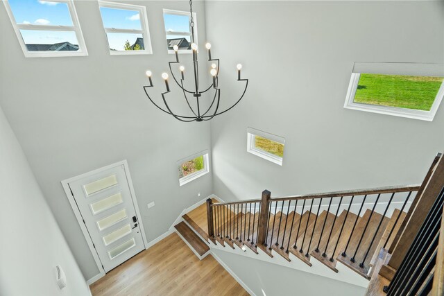 540 Angels Rest Way, Columbia, MO 65203 - staircase featuring wood finished floors, a chandelier, a towering ceiling, plenty of natural light, and baseboards