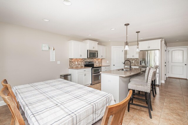 4105 Astoria Way, Columbia, MO 65203 - kitchen with stainless steel appliances, a sink, backsplash, a kitchen bar, and recessed lighting