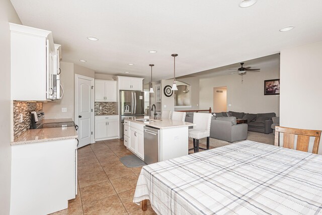 4105 Astoria Way, Columbia, MO 65203 - kitchen featuring appliances with stainless steel finishes, decorative backsplash, a sink, a kitchen bar, and ceiling fan