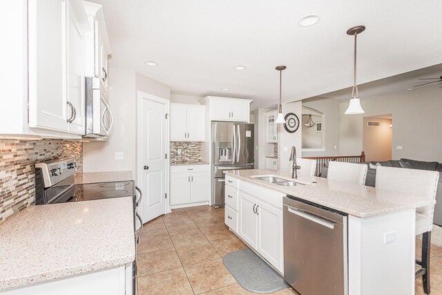 4105 Astoria Way, Columbia, MO 65203 - kitchen with appliances with stainless steel finishes, a sink, a kitchen bar, decorative backsplash, and white cabinetry