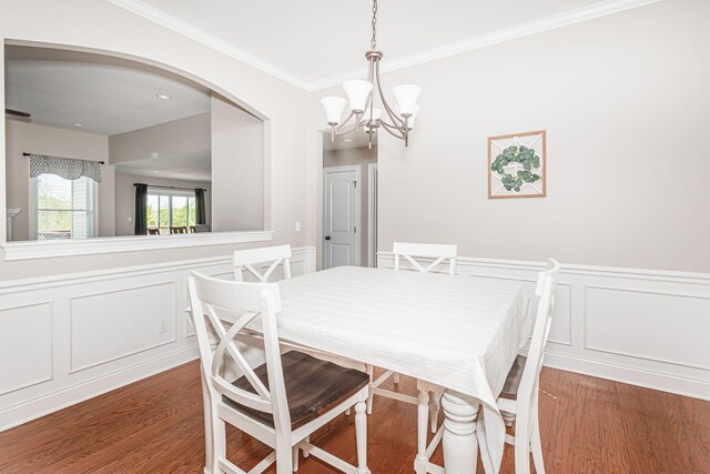 4105 Astoria Way, Columbia, MO 65203 - dining space featuring a chandelier, a decorative wall, wood finished floors, arched walkways, and wainscoting