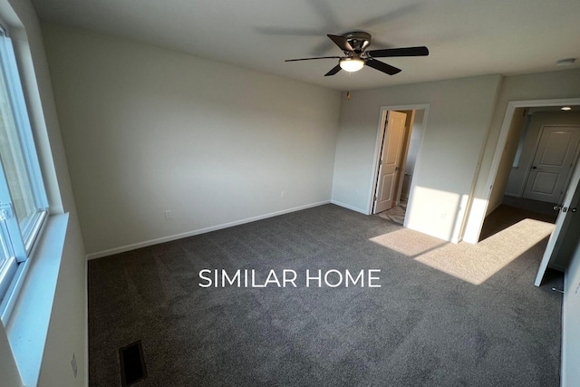 unfurnished bedroom featuring dark carpet, baseboards, and a ceiling fan