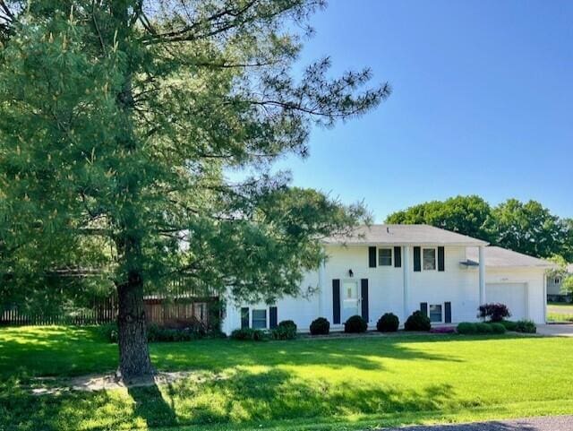 bi-level home featuring an attached garage and a front yard