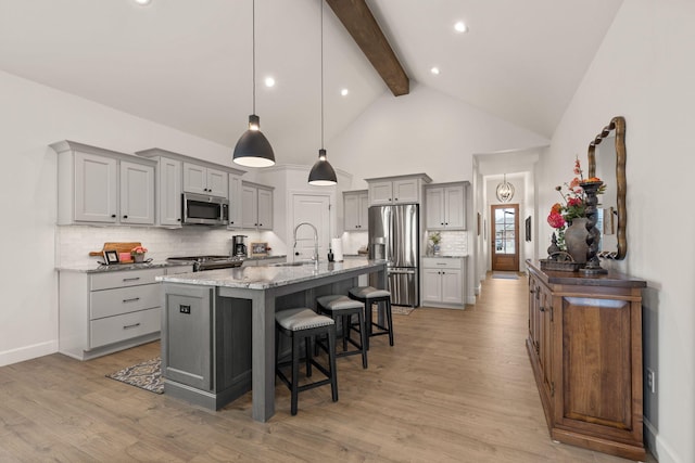 1104 Caymus Ct, Columbia, MO 65201 - kitchen with appliances with stainless steel finishes, gray cabinets, beamed ceiling, a kitchen breakfast bar, and decorative backsplash