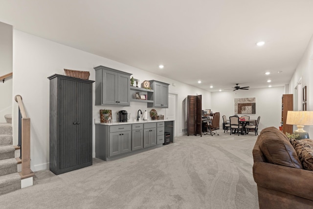 1104 Caymus Ct, Columbia, MO 65201 - living room featuring light colored carpet, bar with sink, stairs, ceiling fan, and recessed lighting