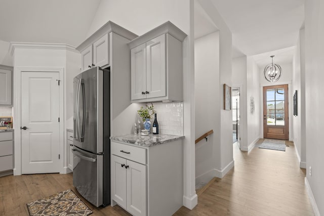 1104 Caymus Ct, Columbia, MO 65201 - kitchen featuring stainless steel fridge, backsplash, light wood-type flooring, and a chandelier