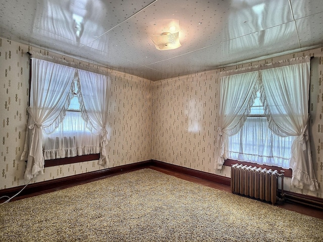 437 N Porter St, Slater, MO 65349 - unfurnished room with radiator heating unit, carpet, wallpapered walls, and baseboards