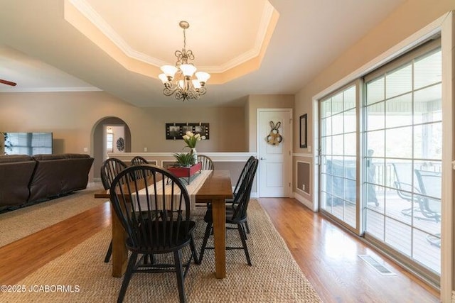 1200 Choctaw Ridge Dr, Holts Summit, MO 65043 - dining area with a tray ceiling, a chandelier, arched walkways, plenty of natural light, and crown molding
