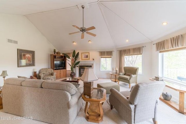 living room featuring lofted ceiling, a ceiling fan, a glass covered fireplace, and recessed lighting