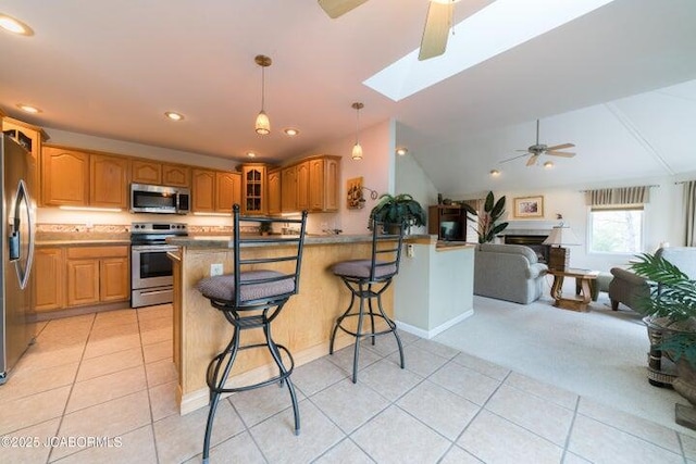 kitchen with stainless steel appliances, ceiling fan, a peninsula, light tile patterned floors, and glass insert cabinets
