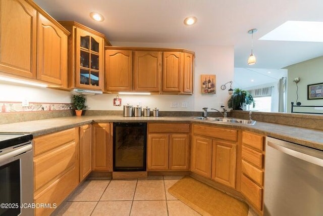 kitchen featuring appliances with stainless steel finishes, a sink, glass insert cabinets, light tile patterned floors, and pendant lighting