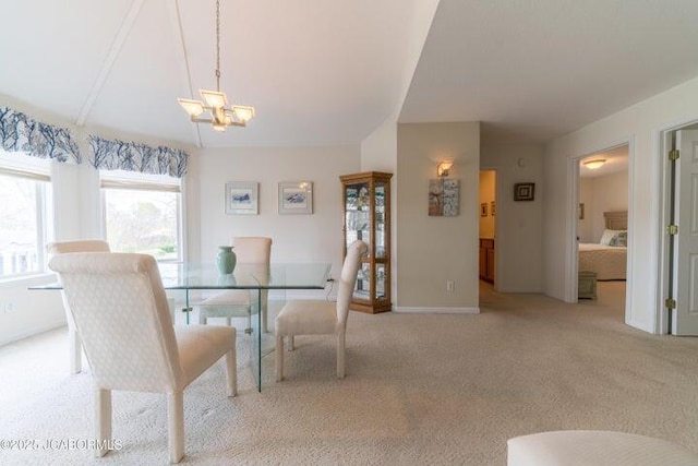 dining room with light colored carpet, a chandelier, and baseboards