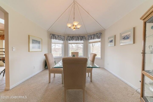 carpeted dining area featuring a chandelier, baseboards, and vaulted ceiling