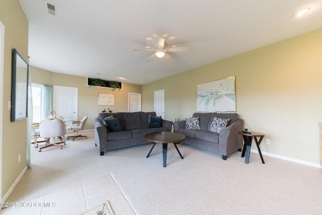 living area with light colored carpet, ceiling fan, and baseboards