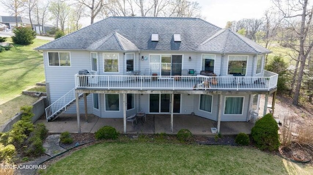 back of property featuring a patio, a yard, roof with shingles, and stairs