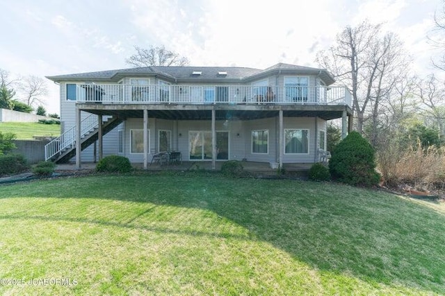 view of front facade with stairway, a wooden deck, and a front yard