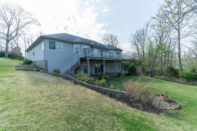 rear view of house featuring stairway, a deck, and a yard