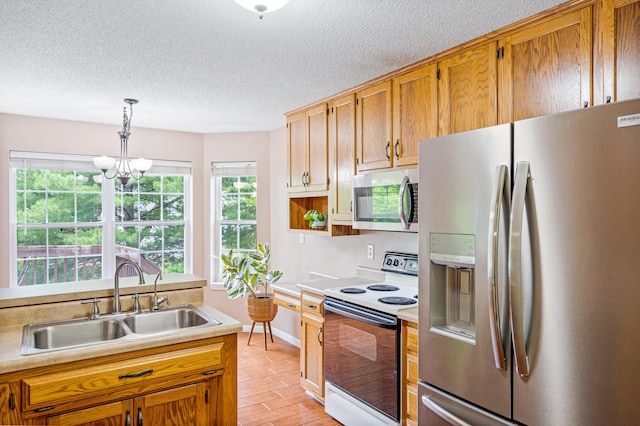 2313 Katy Ln, Columbia, MO 65203 - kitchen featuring appliances with stainless steel finishes, a sink, a chandelier, light countertops, and light wood-style flooring