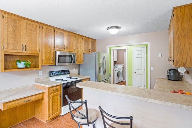 2313 Katy Ln, Columbia, MO 65203 - kitchen with stainless steel appliances, washer and dryer, a peninsula, light countertops, and open shelves