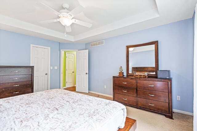 2313 Katy Ln, Columbia, MO 65203 - bedroom featuring a tray ceiling, baseboards, light carpet, and a ceiling fan