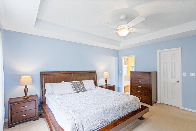 2313 Katy Ln, Columbia, MO 65203 - bedroom featuring a tray ceiling, light colored carpet, baseboards, ceiling fan, and connected bathroom