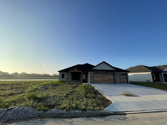 14670 Wellstead Dr, Hallsville, MO 65255 - view of front of home featuring an attached garage, driveway, board and batten siding, and stone siding