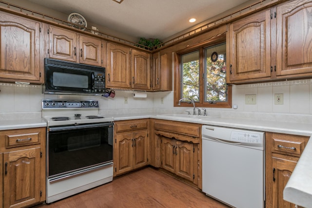2512 Cimarron Dr, Columbia, MO 65203 - kitchen with white appliances, a sink, backsplash, light wood-style floors, and recessed lighting