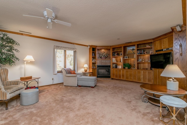 2512 Cimarron Dr, Columbia, MO 65203 - carpeted living room with crown molding, a textured ceiling, a glass covered fireplace, a ceiling fan, and baseboards