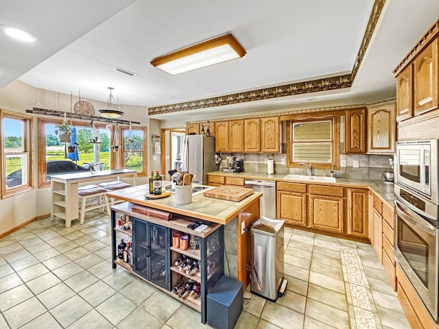 7495 E Schooler Rd, Centralia, MO 65240 - kitchen featuring stainless steel appliances, a sink, open shelves, light tile patterned flooring, and baseboards