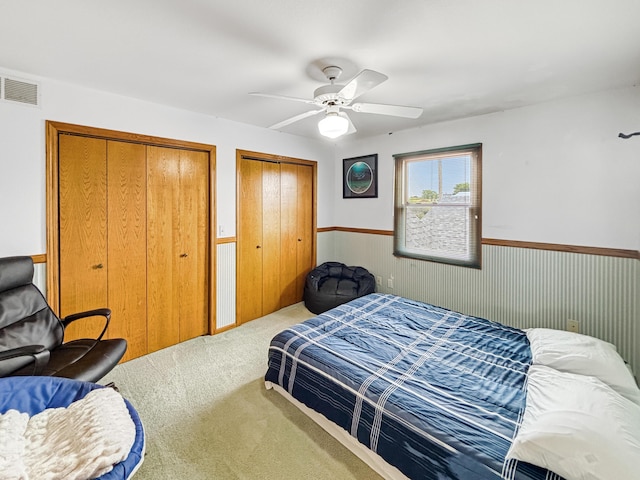 7495 E Schooler Rd, Centralia, MO 65240 - carpeted bedroom with multiple closets, wainscoting, and ceiling fan