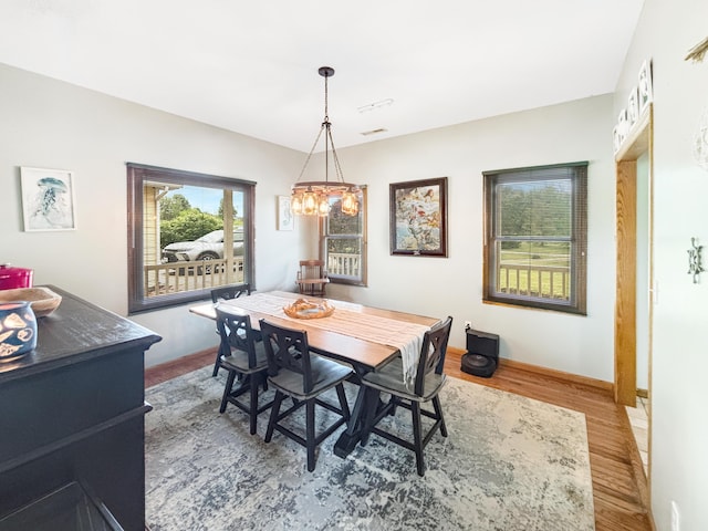 7495 E Schooler Rd, Centralia, MO 65240 - dining area featuring wood finished floors, a chandelier, and baseboards