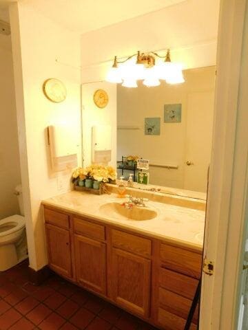 bathroom featuring tile patterned floors, vanity, and toilet