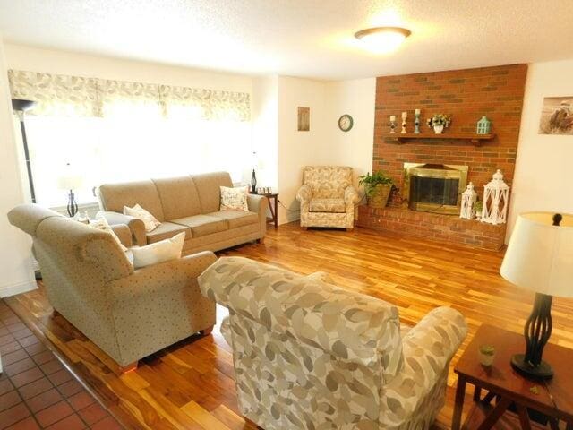 living area with a fireplace and wood finished floors