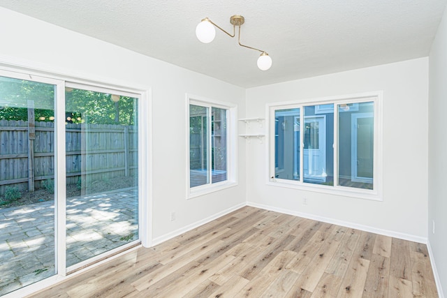 1050 Azoros Dr, Columbia, MO 65203 - unfurnished room featuring light wood-type flooring, baseboards, and a textured ceiling