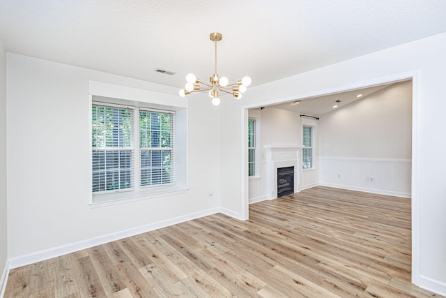 1050 Azoros Dr, Columbia, MO 65203 - unfurnished living room featuring a chandelier, wood finished floors, a fireplace, and baseboards