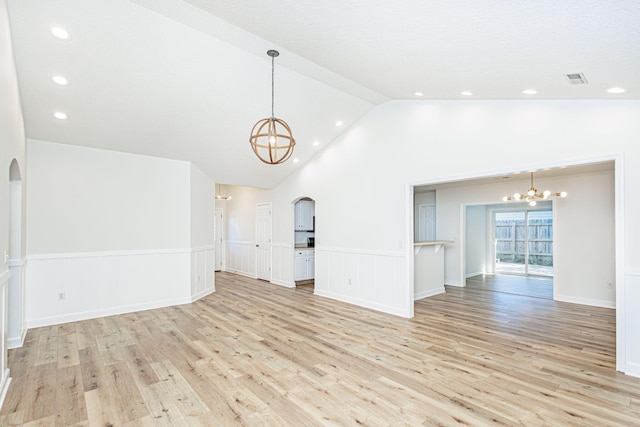 1050 Azoros Dr, Columbia, MO 65203 - unfurnished living room with a chandelier, arched walkways, light wood-type flooring, a wainscoted wall, and recessed lighting