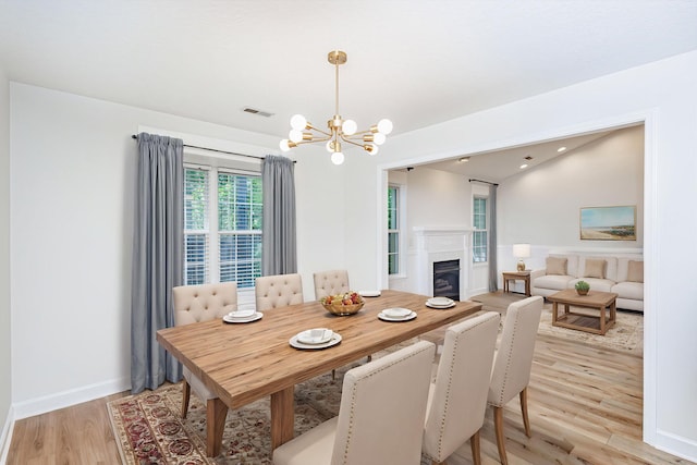 1050 Azoros Dr, Columbia, MO 65203 - dining room with a chandelier, light wood-style flooring, a fireplace, and baseboards