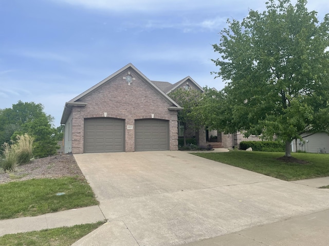 1317 Troon Dr, Columbia, MO 65203 - view of front of house with driveway, brick siding, a front lawn, and a garage