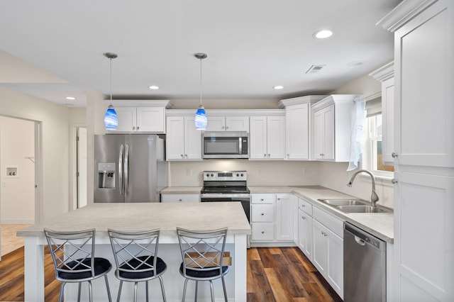 5111 Democracy Dr, Ashland, MO 65010 - kitchen featuring stainless steel appliances, a sink, white cabinetry, light countertops, and a kitchen bar