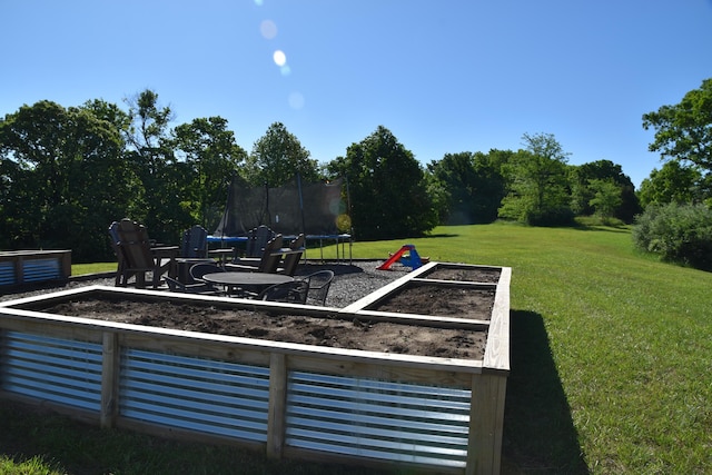 5100 E Dunbar Ln, Centralia, MO 65240 - view of grassy yard featuring a trampoline and a garden