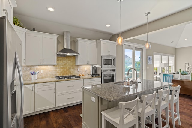 1732 Linkside Dr, Columbia, MO 65201 - kitchen with wall chimney range hood, stainless steel appliances, a sink, vaulted ceiling, and dark wood-type flooring