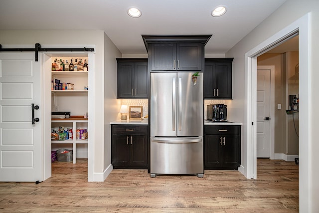 1043 Shore Acres, Columbia, MO 65201 - kitchen with freestanding refrigerator, light wood-type flooring, tasteful backsplash, a barn door, and recessed lighting