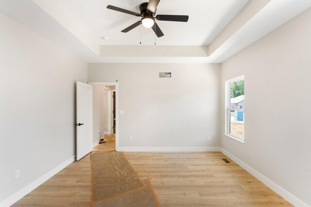 404 Sugarberry Dr, Columbia, MO 65201 - empty room with a tray ceiling, ceiling fan, light wood finished floors, and baseboards