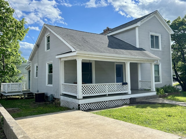 112 W 6th St, Fulton, MO 65251 - traditional-style house featuring a porch, roof with shingles, a front lawn, a chimney, and central air condition unit