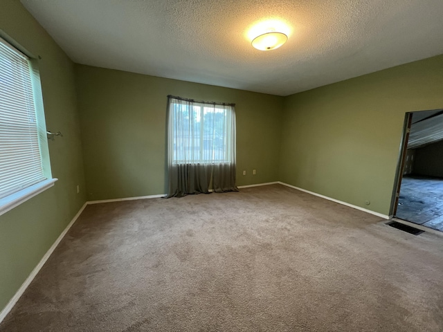 112 W 6th St, Fulton, MO 65251 - empty room featuring healthy amount of natural light, a textured ceiling, and baseboards