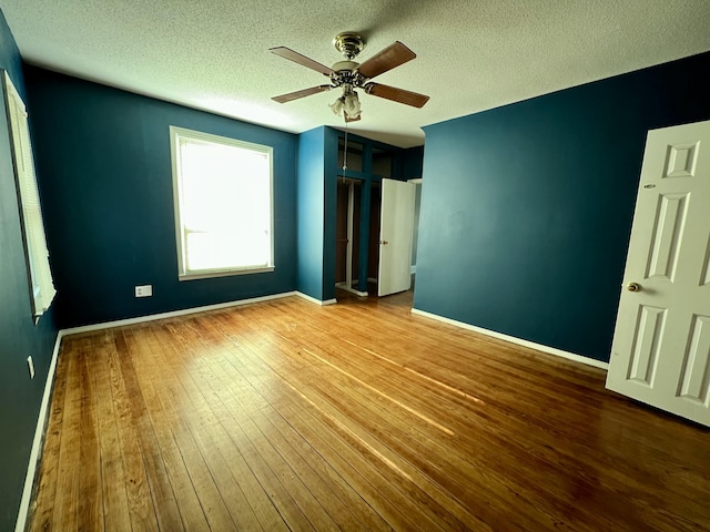 112 W 6th St, Fulton, MO 65251 - unfurnished bedroom with a textured ceiling, hardwood / wood-style flooring, ceiling fan, and baseboards